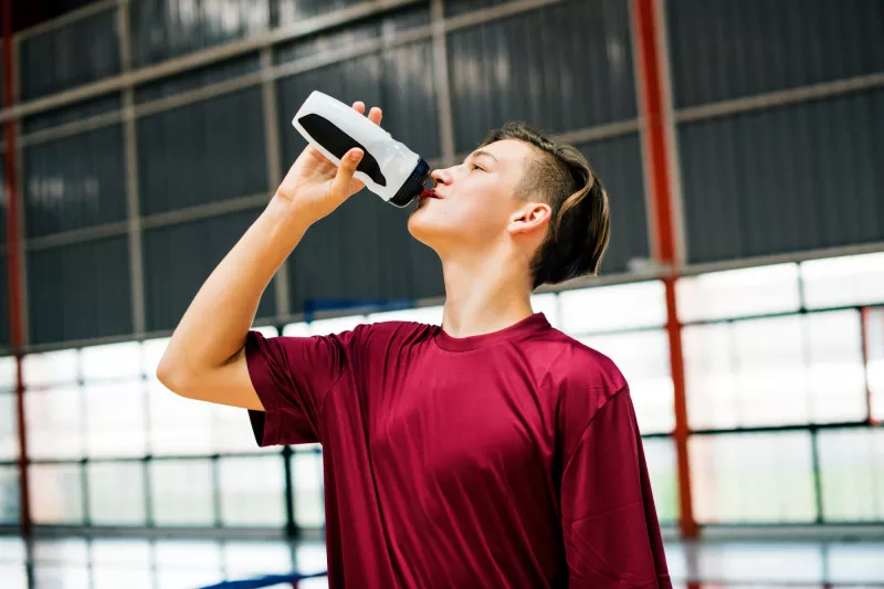 A woman drinking water after exercising.