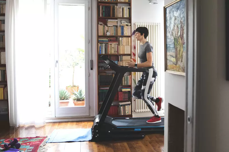 A woman running on the treadmill at home.