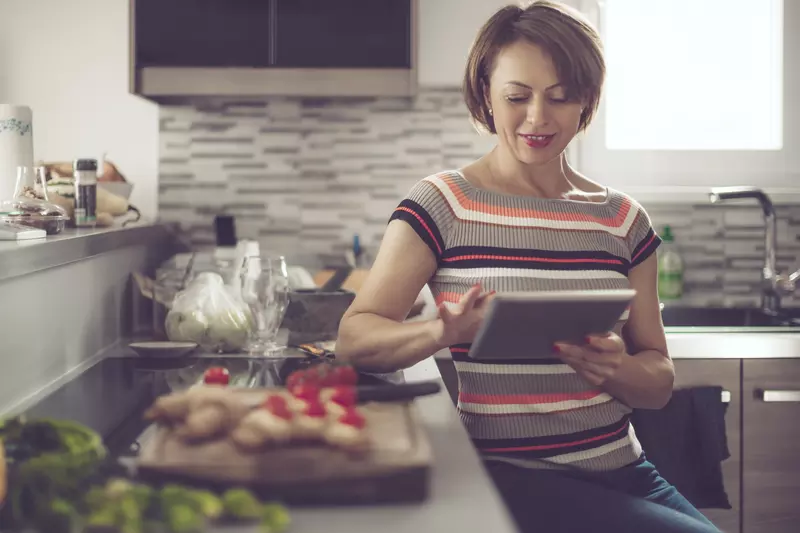 woman in kitchen reading tablet
