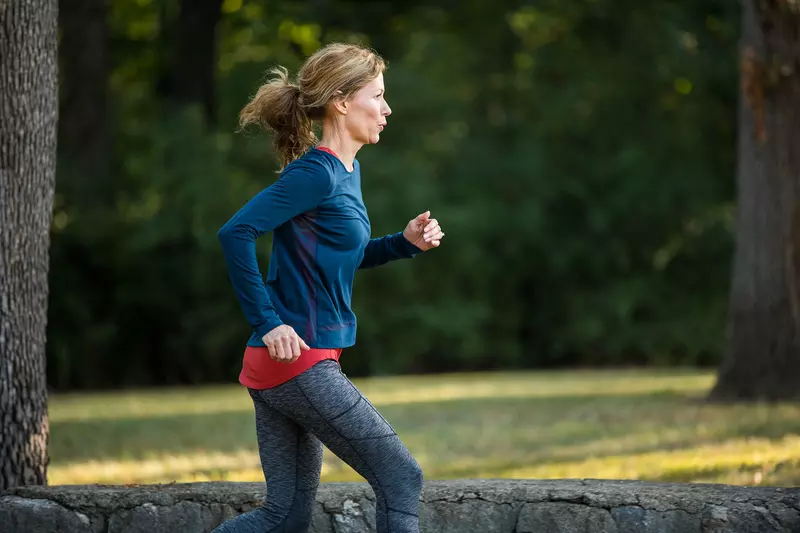 A young woman taking a morning run around in the park.
