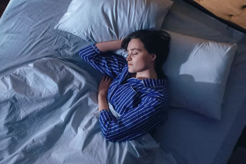 Woman sleeping on her side in bed.