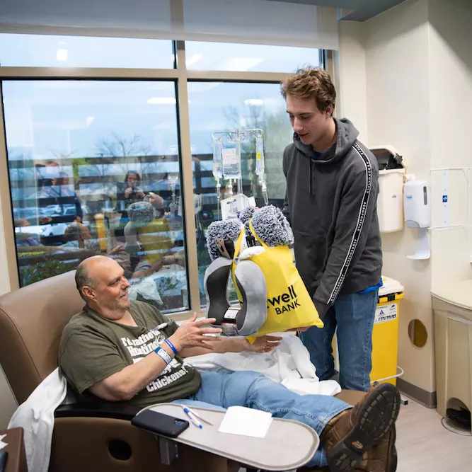 Student gives care bag to cancer patient