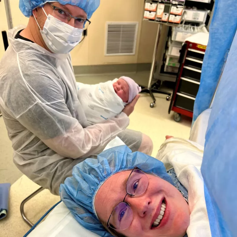 Meredith in her C-Section with her husband holding their newborn baby