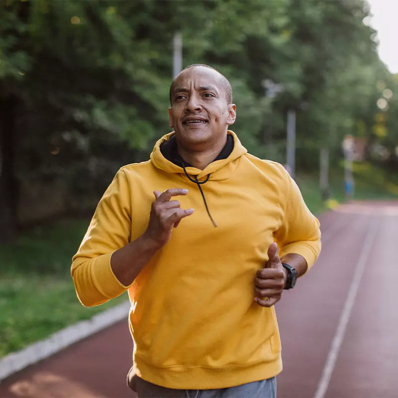 Hispanic man jogging on track
