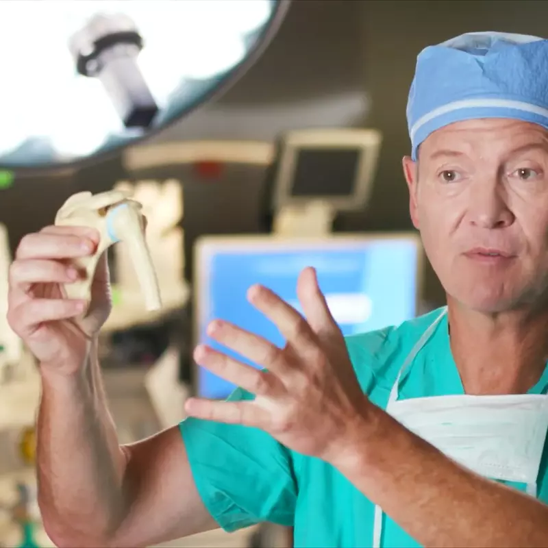 Dr. Mark Mighell Holds A Model of the Human Shoulder Bones in a Surgery Room.