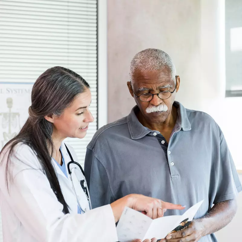 A Doctor Goes Over a Brochure with Her Senior Patient 