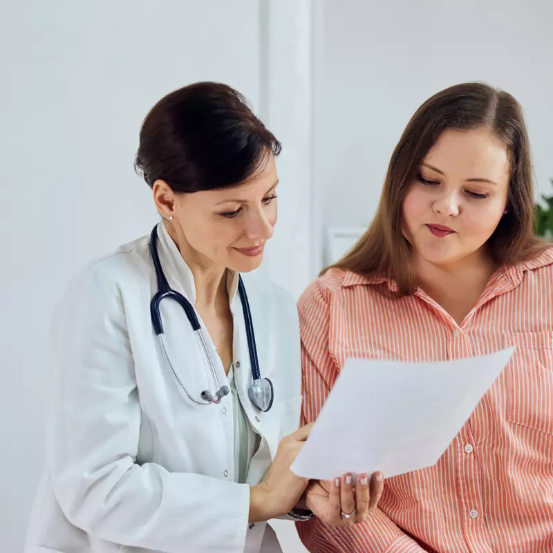 A Physician Goes Over a Chart with a Patient 