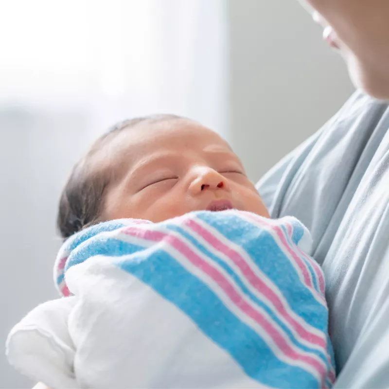 A Close Up of a New Born Baby Being Held