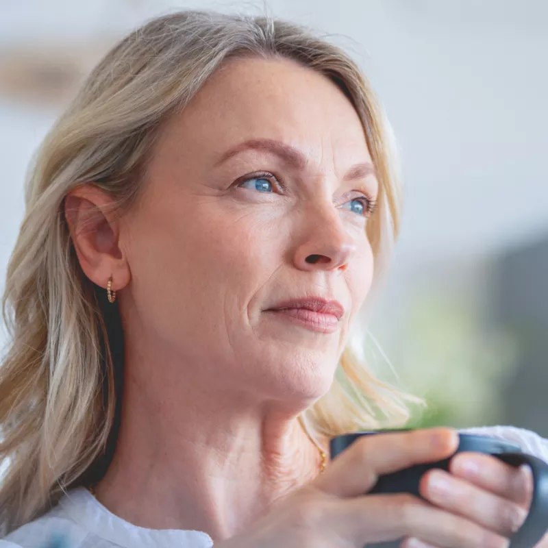 A Woman Sits and Drinks Coffee