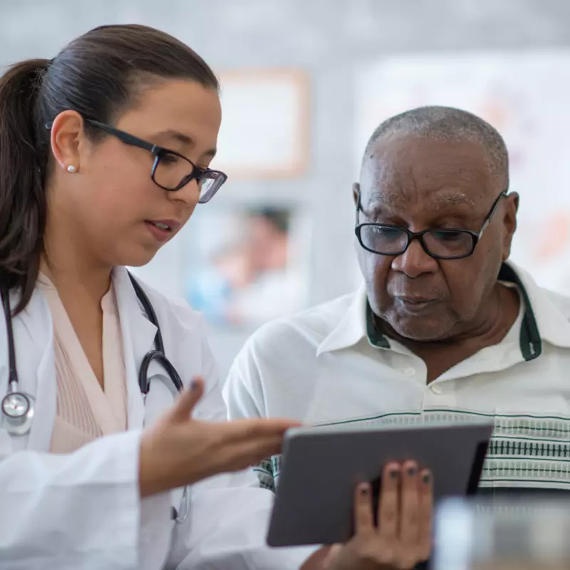A Physician Goes Over a Patient's Chart with Him on a Tablet 