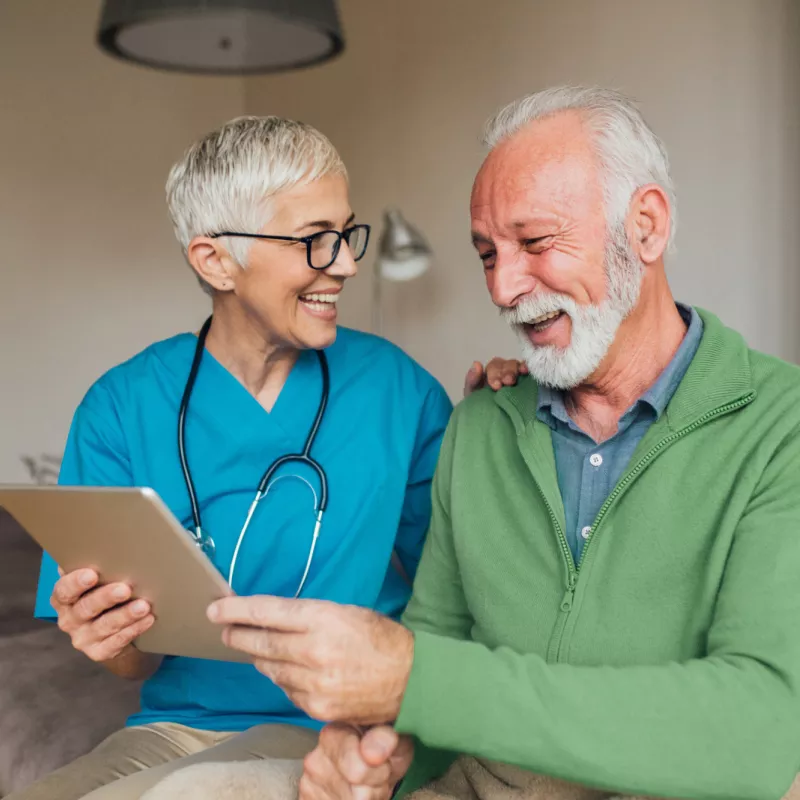 A Nurse Smiles as She Goes Over a Patient's Chart with Him