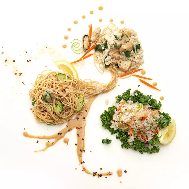 Three mounds of Asian noodles with green garnishes 