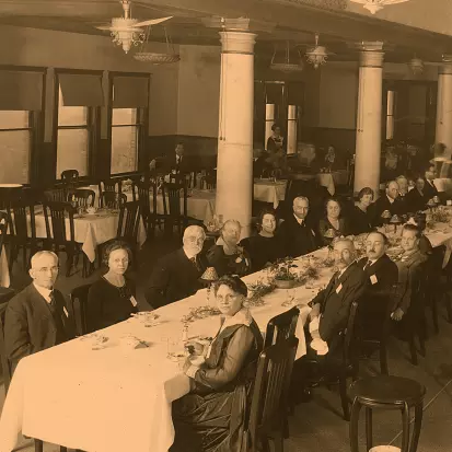 A group of men and women sitting at a long dining table