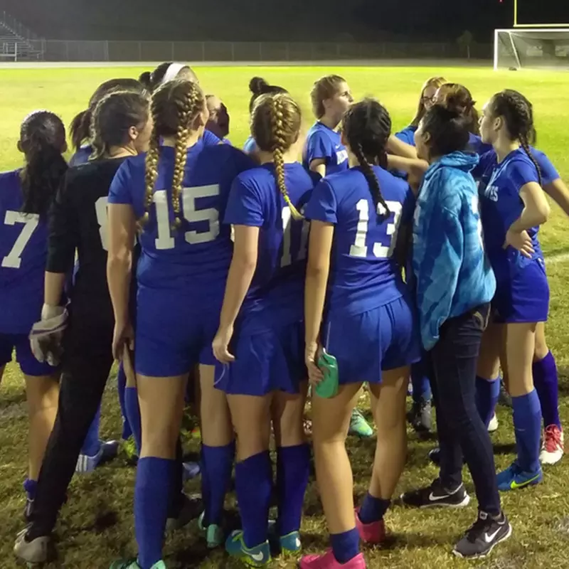 Girls soccer team in a huddle.