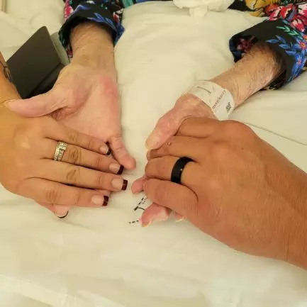 The couple holds hands with their grandmother showing off new wedding rings.