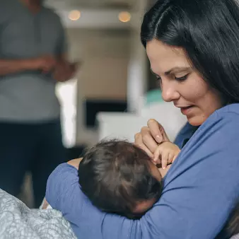 A mother breastfeeds her newborn baby.