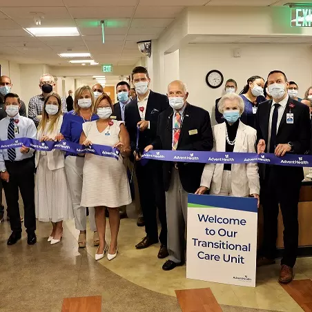 : Accompanied by hospital staff and members of the community, AdventHealth DeLand CEO David Weis cuts the ribbon on the campus’s new Transitional Care Unit.
