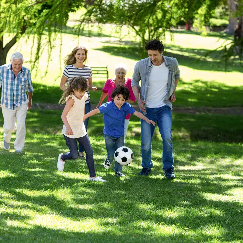 Family runs together after a soccer ball