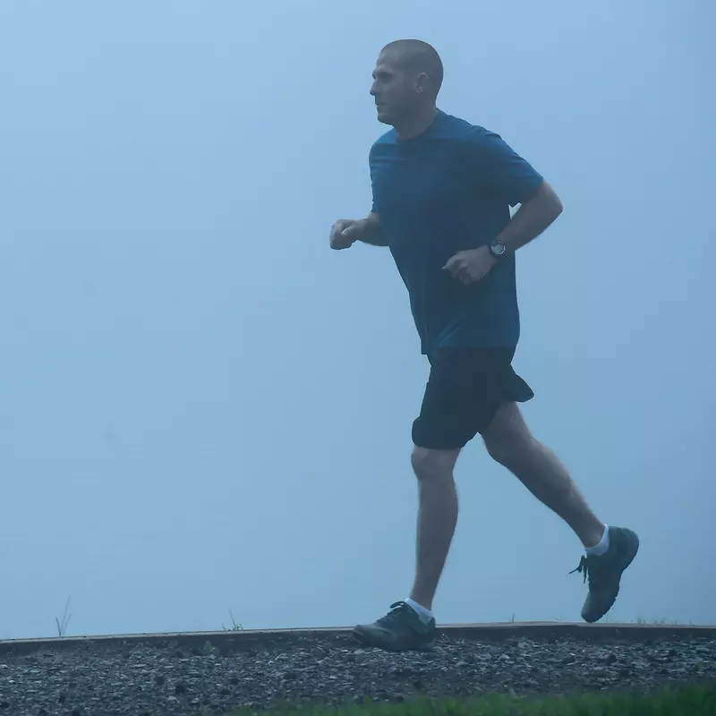 Man out for a jog in the fog.