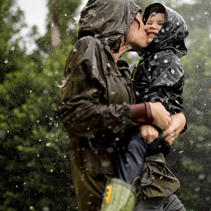 Mom and little boy playing in the rain.