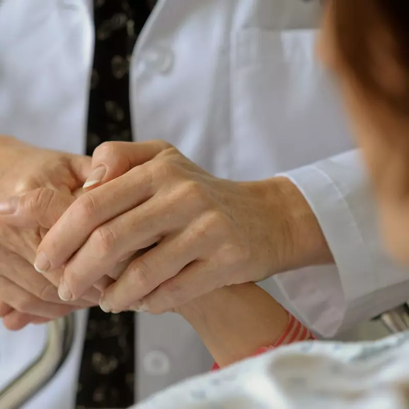 Physician holding hands with patient