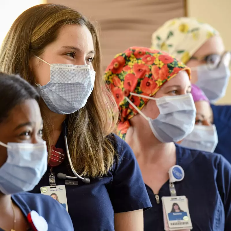 Four masked nurses smiling, diversity