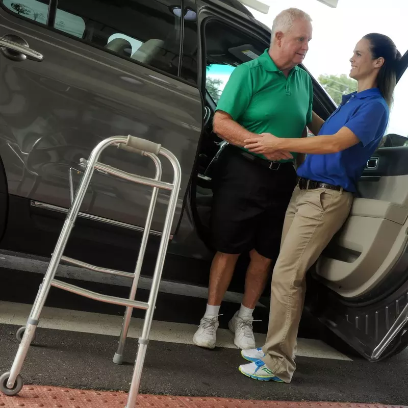 Senior receiving help out of a car