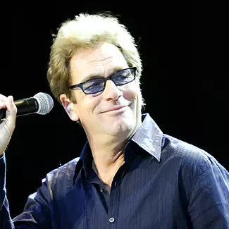 Singer, Huey Lewis, holding a microphone