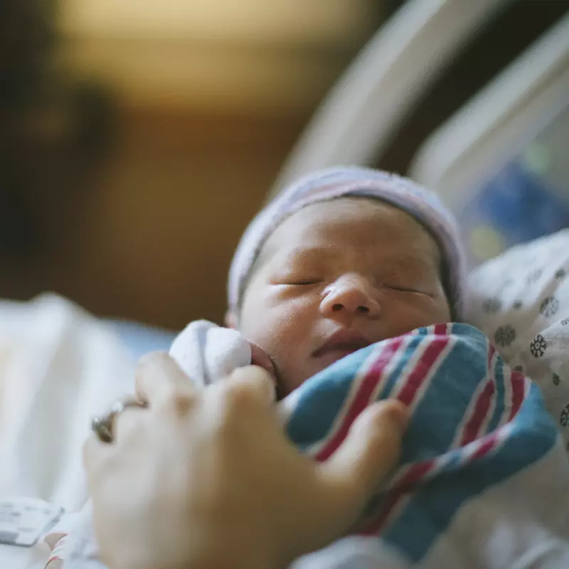 A mother holds her newborn baby in their AdventHealth hospital room
