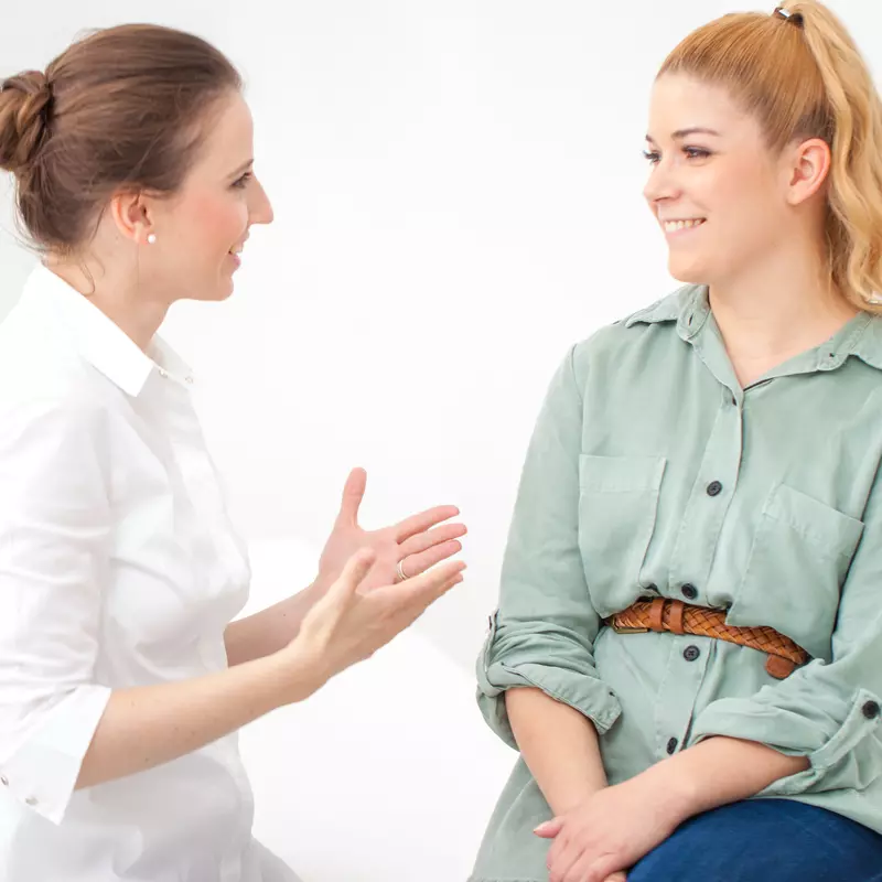 Woman discussing ongoing stomach pain with her doctor