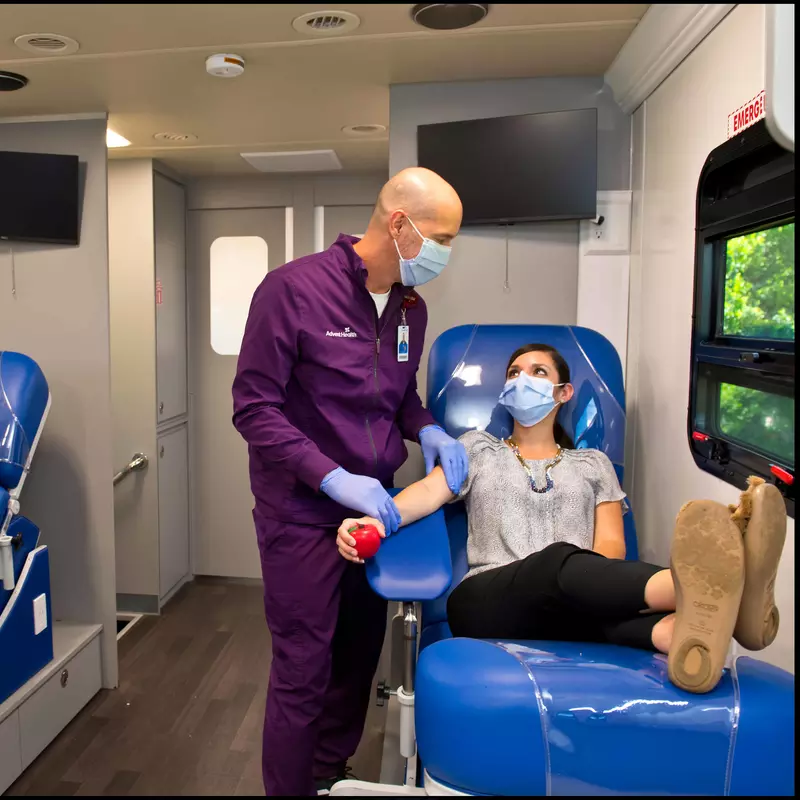 Phlebotomist prepping blood donor in AdventHealth Bloodmobile