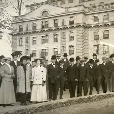 Black and white historical photo of people standing in front of a Sanitarium
