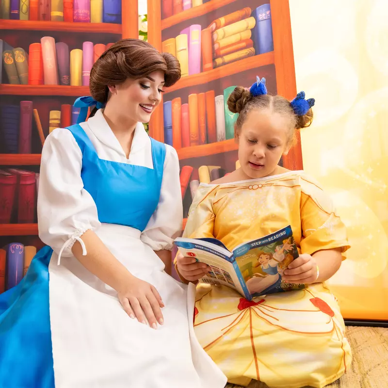 Disney Princess Belle reads with a young patient at AdventHealth for Children in Orlando.