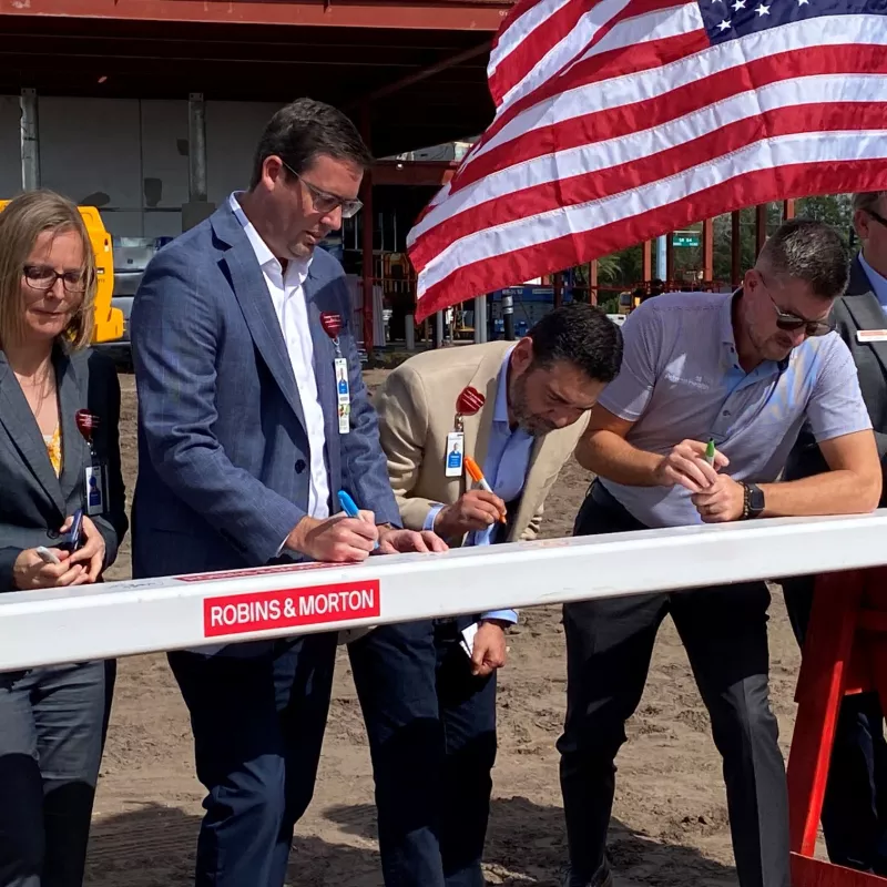 AdventHealth and Robins & Morton leaders sign the beam for AdventHealth Meadow Pointe ER.