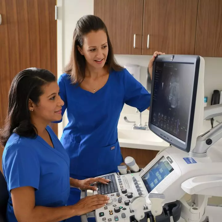 Two ultrasound techs looking at monitor