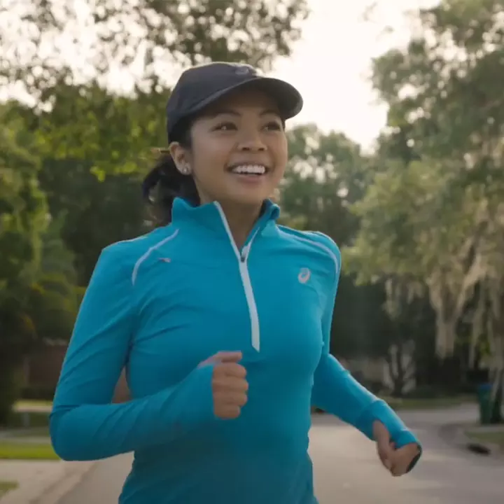 A woman in athletic clothing running outdoors