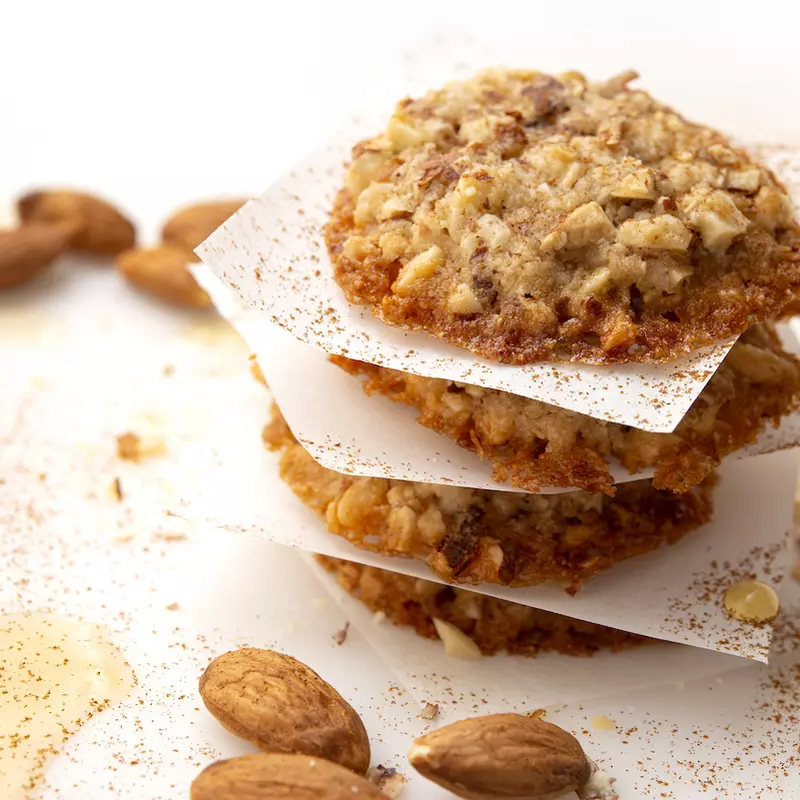 Four stacked almond-maple cookies with almond garnish