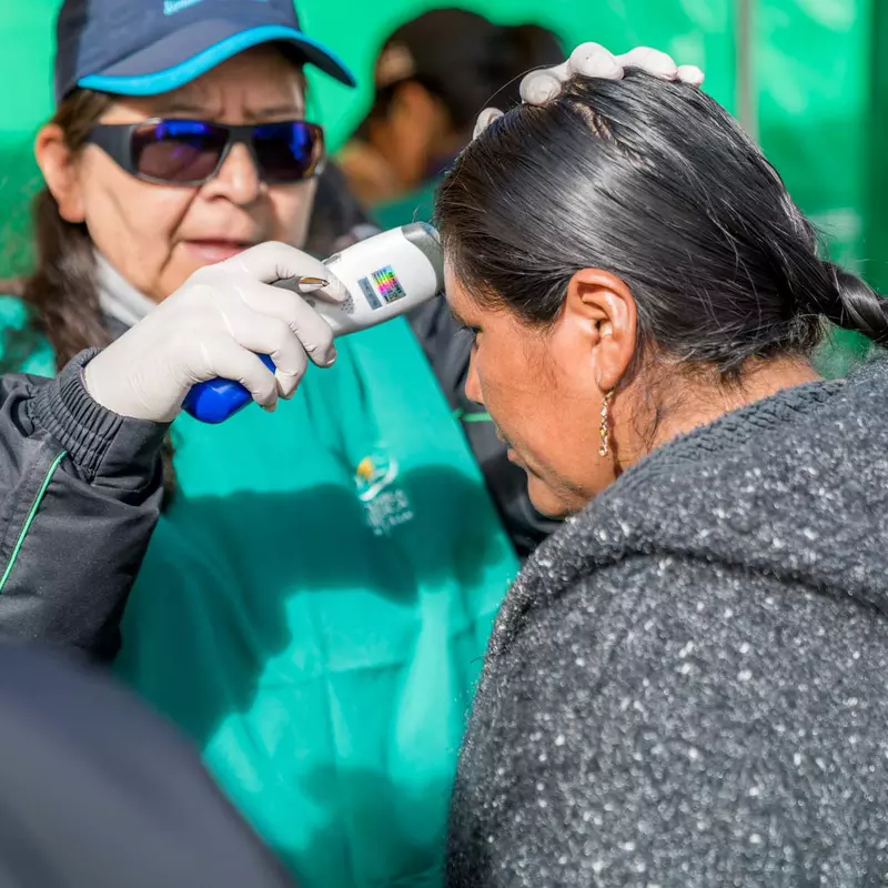 A citizen getting her temperature checked