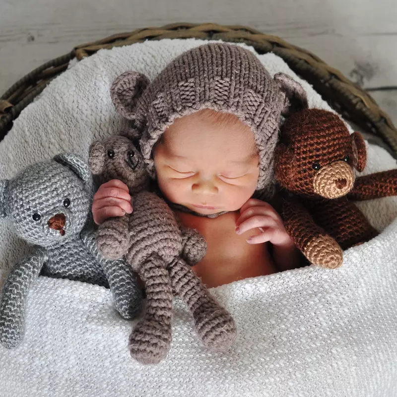 baby sleeping in basket with stuffed animals