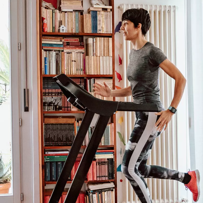 Woman running on a treadmill indoors.