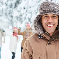 A smiling man standing outside in the snow.