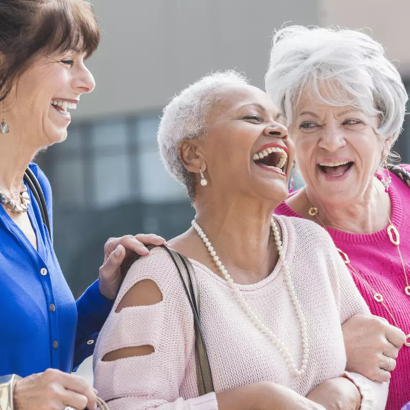 Three women laughing and shopping.