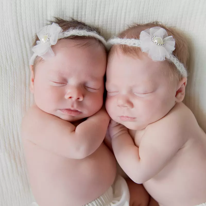 Two newborn babies sleeping side by side