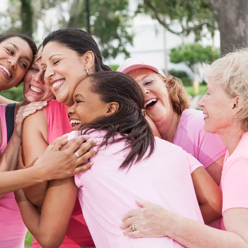 women wearing pink shirts and hugging