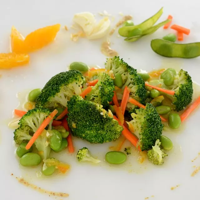 A dish comprised of broccoli, edamame, carrots, and other various ingredients