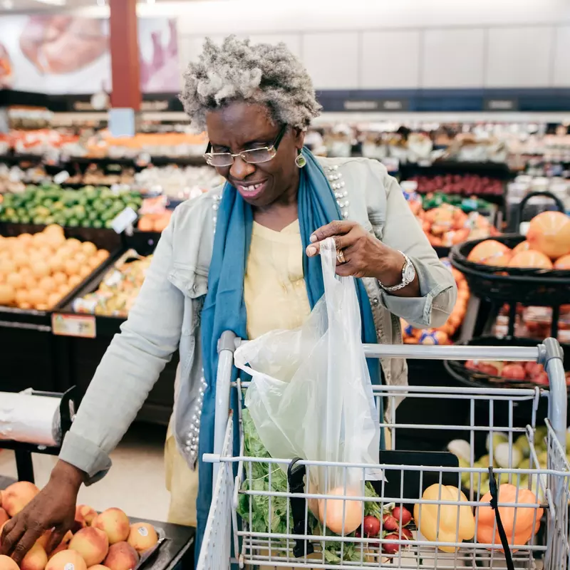 Older woman shopping for produce at the grocery store