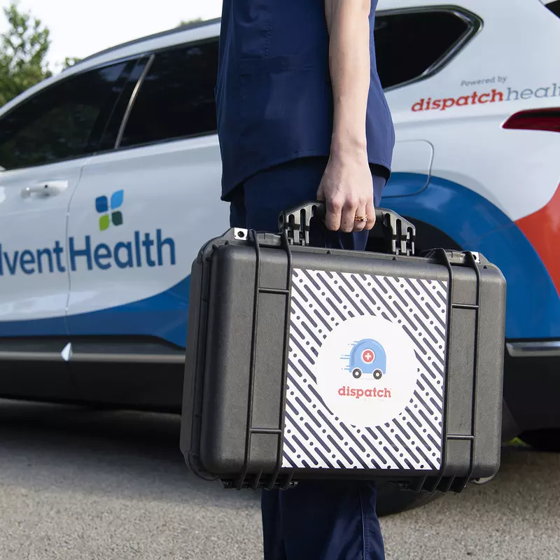 AdventHealth employee holding a briefcase in front of car
