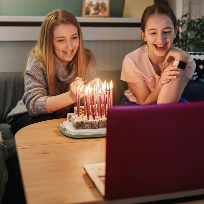 A family celebrating a birthday over video chat. 