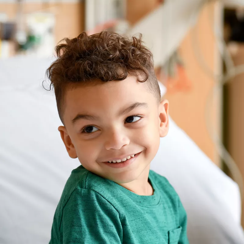 Child sitting in a hospital bed.