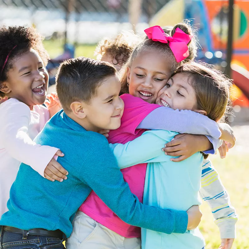 children hugging on a playground